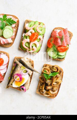 Nahaufnahme des Sortiments offene Sandwiches auf hellem Stein Hintergrund. Schmackhafter gesunder Snack. Draufsicht, flach liegend. Stockfoto