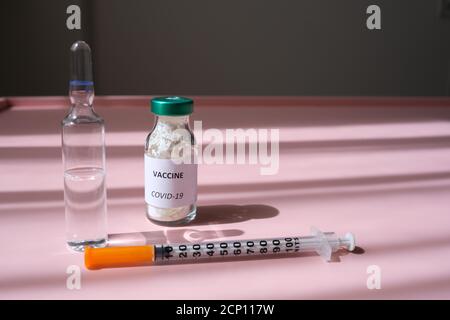 Covid 19 Virus, Gesundheitskonzept mit blauer medizinischer Handschelle mit einem Impfstofffläschchen für die Virusbehandlung Stockfoto