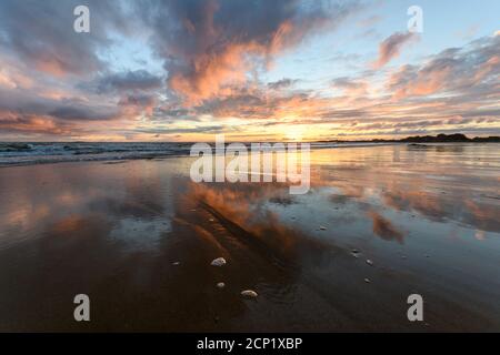 Sonnenuntergang am atlantik mit orangefarbenem Strand und Himmel in Frankreich. Stockfoto