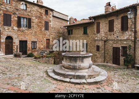 Castiglione d'Orcia Stadtzentrum mit einem alten Brunnen und Kopfsteinpflaster in der Toskana, Italien und Steinhäusern Stockfoto