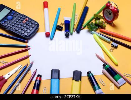 Mockup von leerem Papier, Bleistiften, Umhang, Taschenrechner, Textmarker auf gelbem Hintergrund Stockfoto