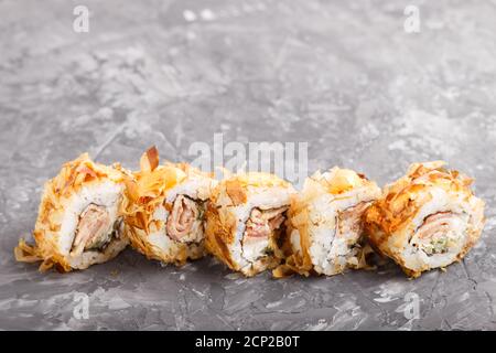 Japanische Maki-Sushi-Rollen mit Thunfisch, Gurke, Käse auf schwarzem Beton-Hintergrund. Seitenansicht, Nahaufnahme, Kopierbereich. Stockfoto