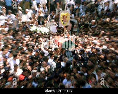 Ein Fahnenbedeckter Sarg Des Verstorbenen Turkischen Filmstars Kemal Sunal Ist Umgeben Von Seinen Portrats Die Von Fans Aufrecht Erhalten Werden Die Versuchen Den Sarg Nach Einem Begrabnisgebet In Der Tesvikiye Moschee In