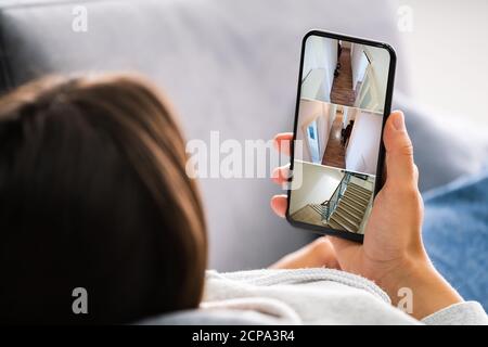 Person Home Security System auf Handy Stockfoto