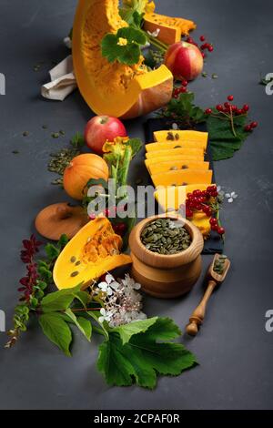 Festliches Herbstdekor aus rohen Kürbissen, Beeren und Blättern. Stockfoto