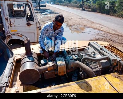 DISTRIKT KATNI, INDIEN - 09. DEZEMBER 2019: Ein indischer Mechaniker repariert hydraulischen JCB-Motor auf der Straße bei Freigelände Werkstatt. Stockfoto