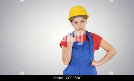 Frau mit Schutzhelm zeigt Faust zur Kamera tat etwas Stockfoto