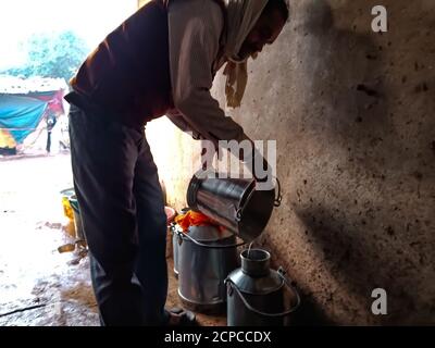 DISTRIKT KATNI, INDIEN - 04. JANUAR 2020: Ein Milchbauer sammelt Milch auf Container in seiner lokalen Milchfarm, einer indischen Farmszene. Stockfoto