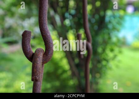 Verrostete Eisenketten halten zusammen. Drehkettenglieder aus Metall in der Nähe. Stockfoto