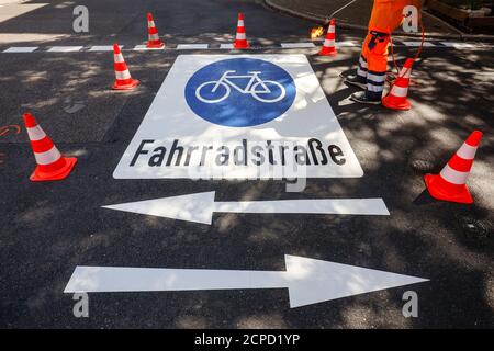 Essen, Ruhrgebiet, Nordrhein-Westfalen, Deutschland - Neue Fahrradstraße, ein Straßenmarkierer beim Auftragen der Fahrrad-Piktogramme, hier in der Busehofstraße in Stockfoto