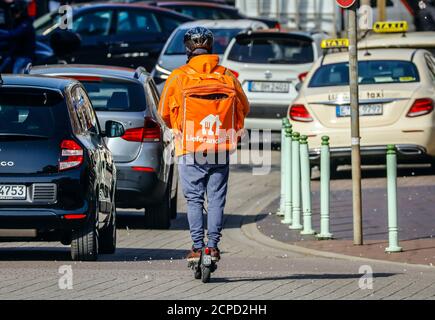 Lieferando Lieferdienst, ein Kurierfahrer unterwegs mit einem Elektroroller liefert bestellte Lebensmittel, Essen, Ruhrgebiet, Nordrhein-Westfalen, Deutschland Stockfoto