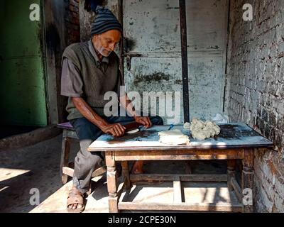 DISTRIKT KATNI, INDIEN - 08. JANUAR 2020: Ein indischer alter Mann, der Samosa auf lokalem Hotel macht. Stockfoto