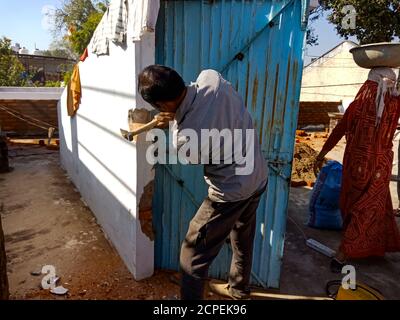 DISTRIKT KATNI, INDIEN - 13. JANUAR 2020: Eine indische Bauarbeiterin schlägt Hammer auf die Wand. Stockfoto