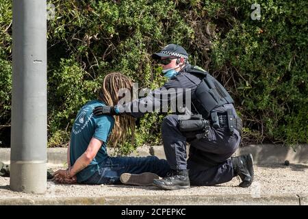 Melbourne, Australien. 19. September 2020. Ein Polizeibeamter in Victoria mit Handschellen an einem Protestanten auf der Seite der Ormond Esplanade, nahe Elwood Beach, der an Anti-Masken- und Anti-Lockdown-Protesten teilgenommen hatte, die aus dem Elsternwick Park, Melbourne, Australien, gezogen waren. Kredit: Michael Currie/Alamy Live Nachrichten Stockfoto