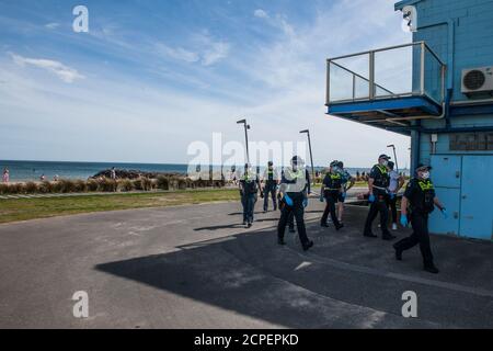 Melbourne, Australien. September 2020. Victoria Polizeibeamte gehen am Surfclub am Elwood Beach vorbei, nachdem sie den Strand gefegt hatten, um gegen Masken und Sperrwehren protestierende Demonstranten zu protestieren, die von einem Protest im Elsternwick Park, Melbourne, Australien, aus dem Weg gegangen waren. Kredit: Michael Currie/Alamy Live Nachrichten Stockfoto