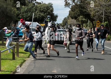 Melbourne, Australien. 19. September 2020. Eine Gruppe von Demonstranten flüchtet vor Polizeibeamten aus Victoria, die versuchen, sie in einer Strandstraße in Elwood abzuschneiden, nachdem ein Anti-Maske- und Anti-Lockdown-Protest aus dem Elsternwick Park, Melbourne, Australien, gezogen war. Kredit: Michael Currie/Alamy Live Nachrichten Stockfoto