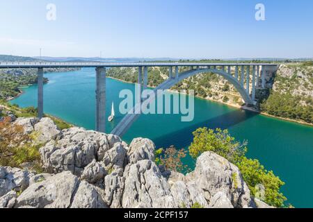 Eine Autobahn Brücke über den Fluss Krka in der Nähe der Stadt Trogir, Šibenik-Knin, Kroatien. Segelboote Segeln auf dem Fluss. Stockfoto