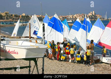 Briefing vor dem Start der Boote. Kinder Matrosen Schule, kleines Segelboot. Studenten des Club Nautique d'Antibes. Kleine Segelboote in der Bucht von Plage du Ponteil. Stockfoto