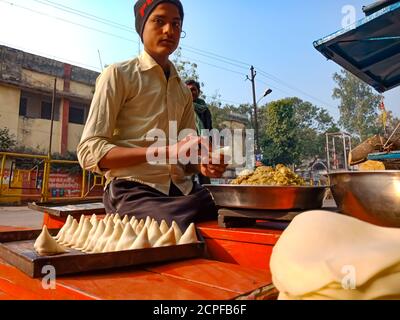 DISTRIKT KATNI, INDIEN - 18. JANUAR 2020: Ein indischer Junge, der Samosa an der Straßenecke macht. Stockfoto