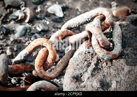 Rostige Kette auf einem Strandfelsen Stockfoto