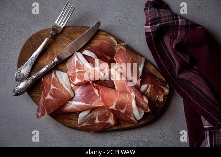 Italienischer Prosciutto oder Jamon mit Rosmarin, rohem Schinken Stockfoto