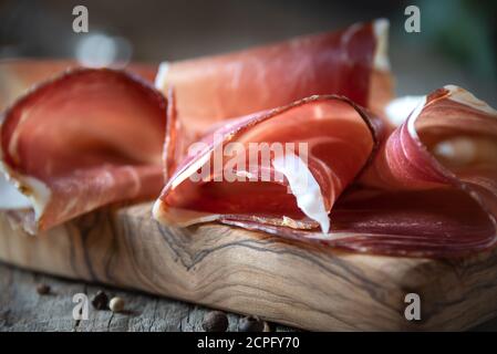 Italienischer Prosciutto oder Jamon mit Rosmarin, rohem Schinken Stockfoto