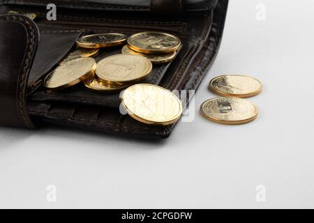 Münzen im Wert von 1 Dollar werden aus einem Geldbeutel gegossen Auf weißem Hintergrund Stockfoto
