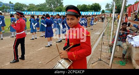 DISTRIKT KATNI, INDIEN - 15. AUGUST 2019: Ein indischer Schuljunge spielt Trommel mit Stöcken auf Stadtspielplatz für nationale Unabhängigkeitstag-Veranstaltungen. Stockfoto