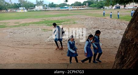 DISTRIKT KATNI, INDIEN - 17. AUGUST 2019: Indische Schulkinder, die sich nach dem Verlassen der Nebenstraße treffen, um am Boden zu spielen. Stockfoto