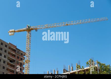 Bau Kran und Gebäude im Bau gegen blauen Himmel. Industriedesign Stockfoto