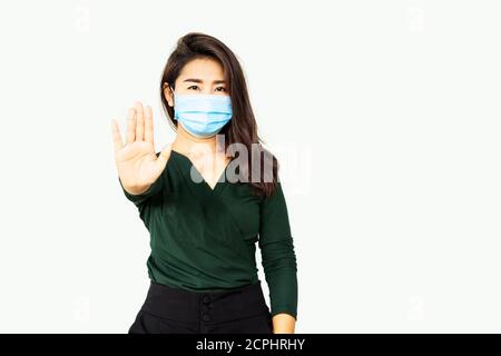 Asiatische Frau trägt Schutzmaske zeigt Hand Stop Geste, soziale Distanzierung, Stop covid-19 Konzept Stockfoto