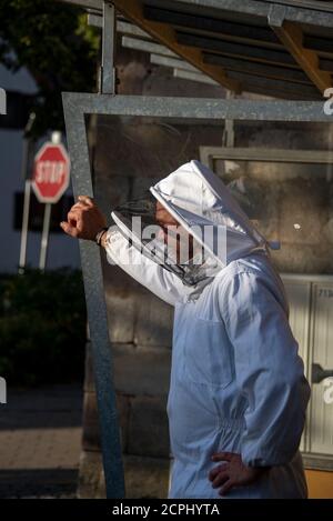 Imker steht an einer Bushaltestelle Stockfoto