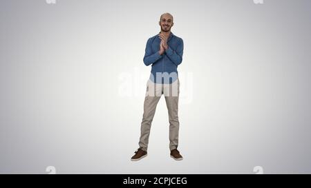 Junger arabischer Mann steht klatscht seine Hände lächelnd auf Steigung ba Stockfoto