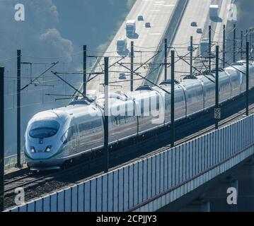 DER ICE-Zug der Deutschen Bahn AG fährt auf der Hochgeschwindigkeitsstrecke Köln-Frankfurt, im Hintergrund fahren Autos und Lastwagen auf der Autobahn A3, Neustadt Wied, Stockfoto