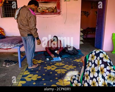 DISTRIKT KATNI, INDIEN - 16. JANUAR 2020: Indischer Dorfmensch zahlt Ratenzahlung für Micro Finance Darlehen Rückzahlung in kleinen Gruppe Meeting-Programm. Stockfoto