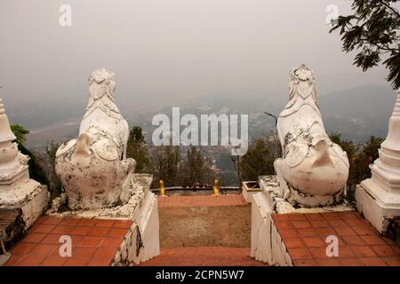 White singha Statue Wächter am Wat Phra, dass Doi Kong Mu Tempel mit Landschaft und Stadtbild von MaeHongSon Hügel Tal Stadt in Mae Hong Son, Thailand Stockfoto
