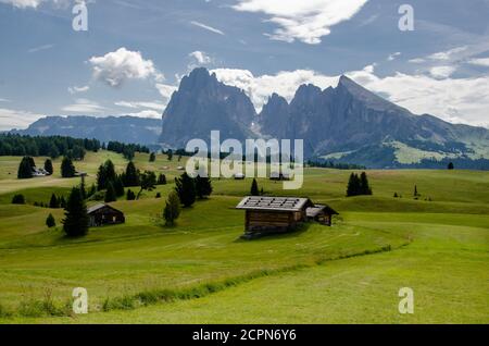 Landschaftlich schöne Aussicht auf Cottages bei teilweise sonnigem Wetter, malerisch. Seiser Alm oder Seiser Alm mit Langkofelgruppe, Südtirol, Stockfoto