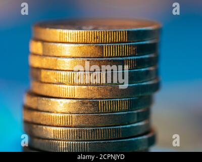 Nahaufnahme des Euro-Münzstapels auf blauem Hintergrund. Stockfoto