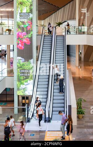 Sevilla, Spanien - 18. September 2020: Menschen an der automatischen Treppe des Lagoh Shopping Centers tragen Schutzmaske wegen Coronavirus covid-19. Neue Norm Stockfoto