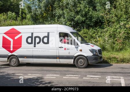 Weißer DPD Lieferwagen (Mercedes) mit vertrauter roter Box auf der ländlichen Cornish Straße. Für ländliche Lieferdienste in Großbritannien, Paketlieferungen, Kurierdienste. Stockfoto