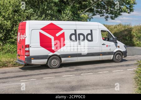 Weißer DPD Lieferwagen (Mercedes) mit vertrauter roter Box auf der ländlichen Cornish Straße. Für ländliche Lieferdienste in Großbritannien, Paketlieferungen, Kurierdienste. Stockfoto