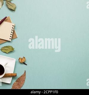 Herbstkonzept. Notizbuch und schwarzer Kaffee mit trockenen Blättern auf grünem Hintergrund. Flach liegend, Draufsicht, Kopierplatz. Arbeits- und Studienort Stockfoto