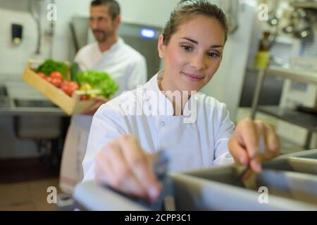 Weibliche Köchin garnieren Mahlzeit auf der Theke in der kommerziellen Küche Stockfoto