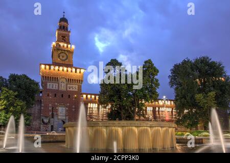 Schloss Sforza (Castello Sforzesco) in Mailand, Italien bei Nacht und der Brunnen davor. Stockfoto