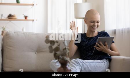 Lächelnder kranker Krebspatient spricht zu Hause auf einem Tablet Stockfoto
