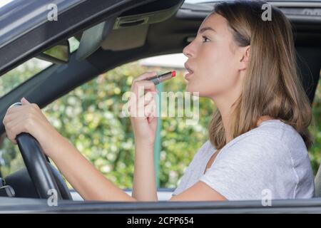 Frau repariert Make-up in einem Auto Stockfoto