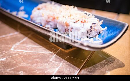 Typisch japanisches Gericht mit Sushi, Reis und Fisch, mit Sauce, Salat, Sushimi und Sesam. Horizontale Ansicht Stockfoto