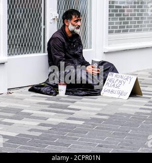 London, Großbritannien, 19. September 2020, Obdachloser Mann auf dem Bürgersteig sitzend, der allein um Geld bettelt und die Wohnungskrise des Vereinigten Königreichs hervorhebt Stockfoto