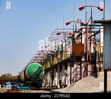 Eisenbahn-Öltank Tankstelle oder Terminal auf Ölraffinerie-Anlage in der Wüste. Feuerschutzanlage mit Feuerlöschern. Blauer Himmel Hintergrund. Taraz Stadt. Stockfoto