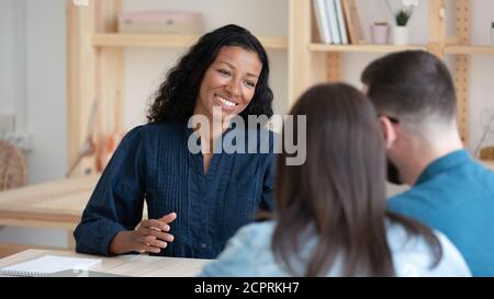 Lächelnd African American maaltor Manager Beratung glücklich junges Paar Stockfoto
